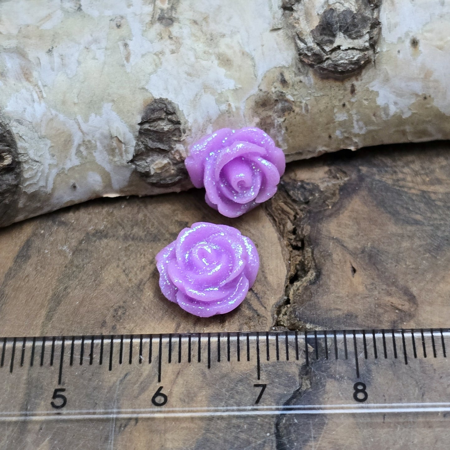 Das Bild zeigt glitzernde Röschen aus Resin – 11mm – Violett – Romantische Blüten für funkelnde Schmuckkreationen ✨💜