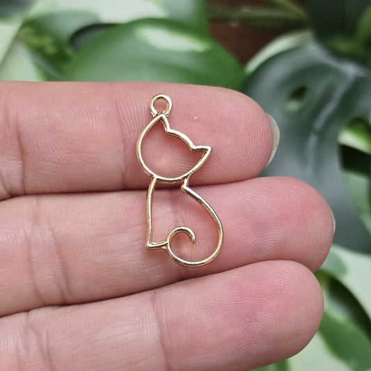 Das Bild zeigt einen filigranen Anhänger in Katzenform. Die Anhänger sind goldfarben und zeichnen sich durch ein zartes, detailliertes Design aus. Die Katzen sind elegant und geschwungen, mit feinen Linien und einer klaren, minimalistischen Form. Die Anhänger haben eine Größe von ca. 25mm und eignen sich perfekt für die Schmuckherstellung oder als dekorative Accessoires.