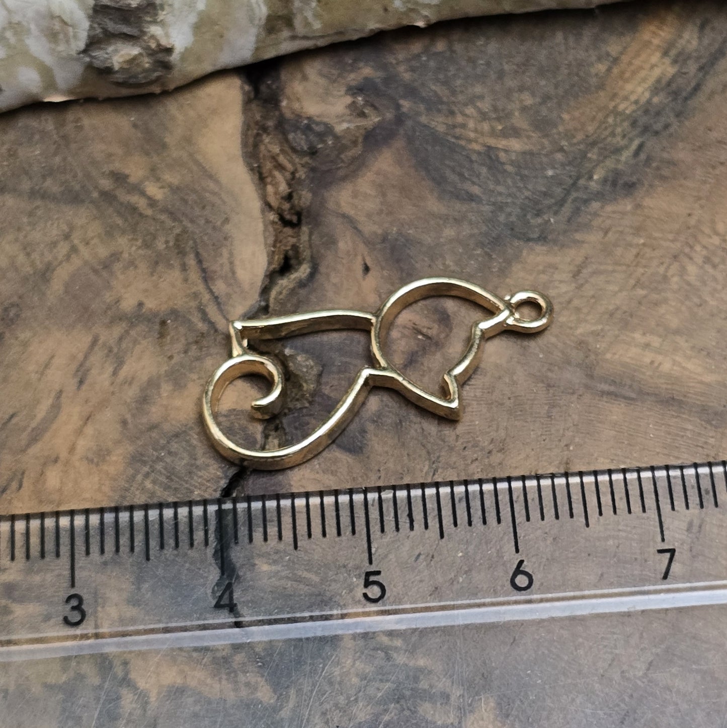 Das Bild zeigt einen filigranen Anhänger in Katzenform. Die Anhänger sind goldfarben und zeichnen sich durch ein zartes, detailliertes Design aus. Die Katzen sind elegant und geschwungen, mit feinen Linien und einer klaren, minimalistischen Form. Die Anhänger haben eine Größe von ca. 25mm und eignen sich perfekt für die Schmuckherstellung oder als dekorative Accessoires.