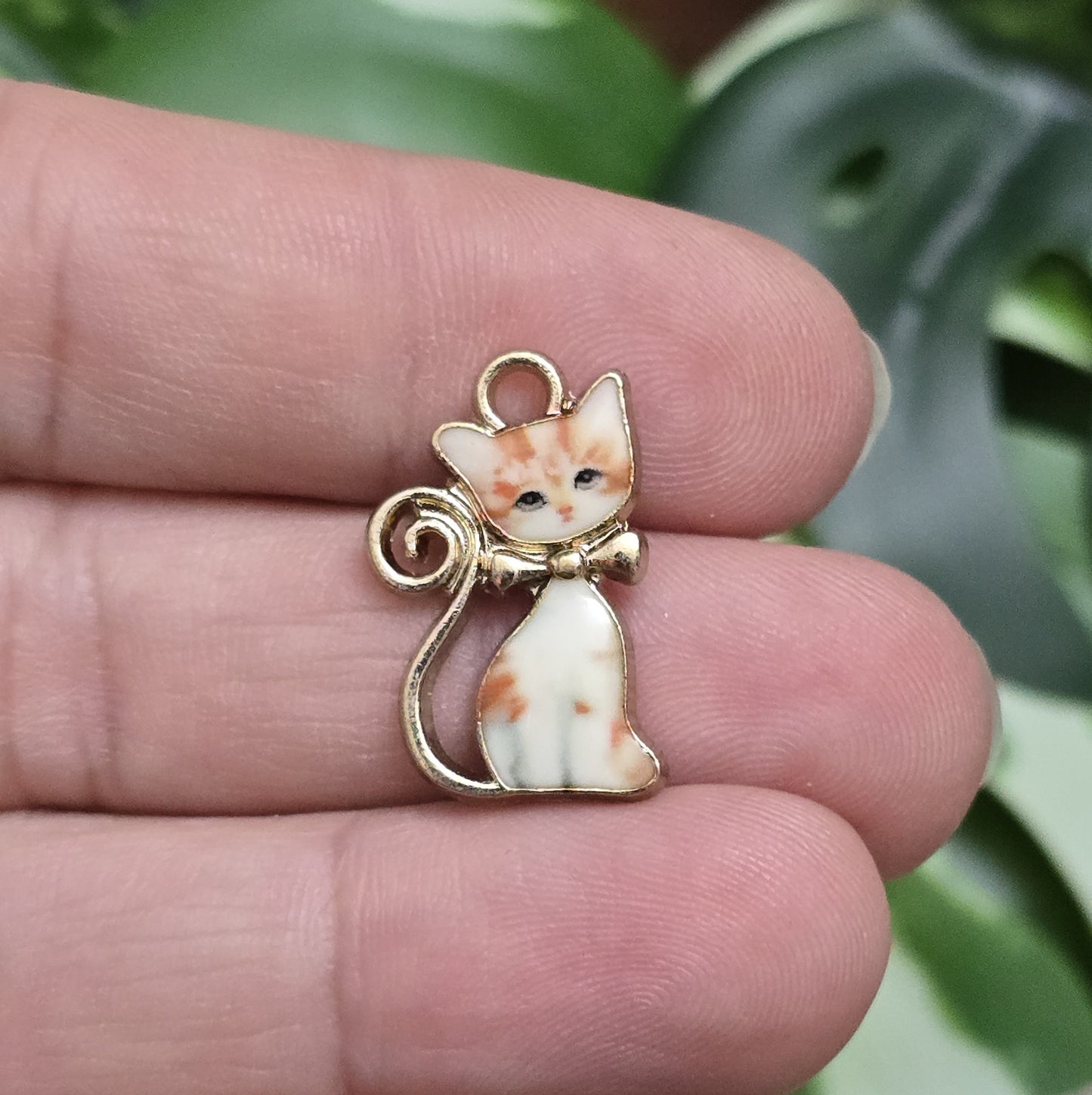Das Bild zeigt einen goldfarbenen Anhänger mit einer rot getigerten Katze. Die Katze ist detailliert mit einem auffälligen rot-getigerten Fellmuster dargestellt, das dem Anhänger eine lebendige und energiegeladene Ausstrahlung verleiht. Der Anhänger hat eine elegante goldfarbene Umrandung, die das Design zusätzlich betont. Mit einer Größe von ca. 21mm eignet sich der Anhänger perfekt für Schmuckkreationen oder kreative DIY-Projekte.