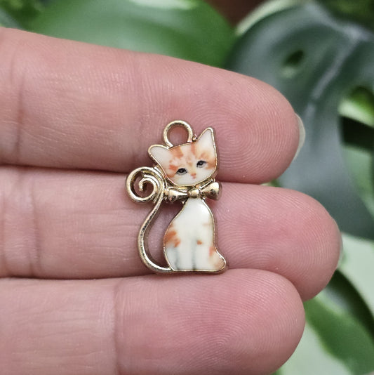 Das Bild zeigt einen goldfarbenen Anhänger mit einer rot getigerten Katze. Die Katze ist detailliert mit einem auffälligen rot-getigerten Fellmuster dargestellt, das dem Anhänger eine lebendige und energiegeladene Ausstrahlung verleiht. Der Anhänger hat eine elegante goldfarbene Umrandung, die das Design zusätzlich betont. Mit einer Größe von ca. 21mm eignet sich der Anhänger perfekt für Schmuckkreationen oder kreative DIY-Projekte.