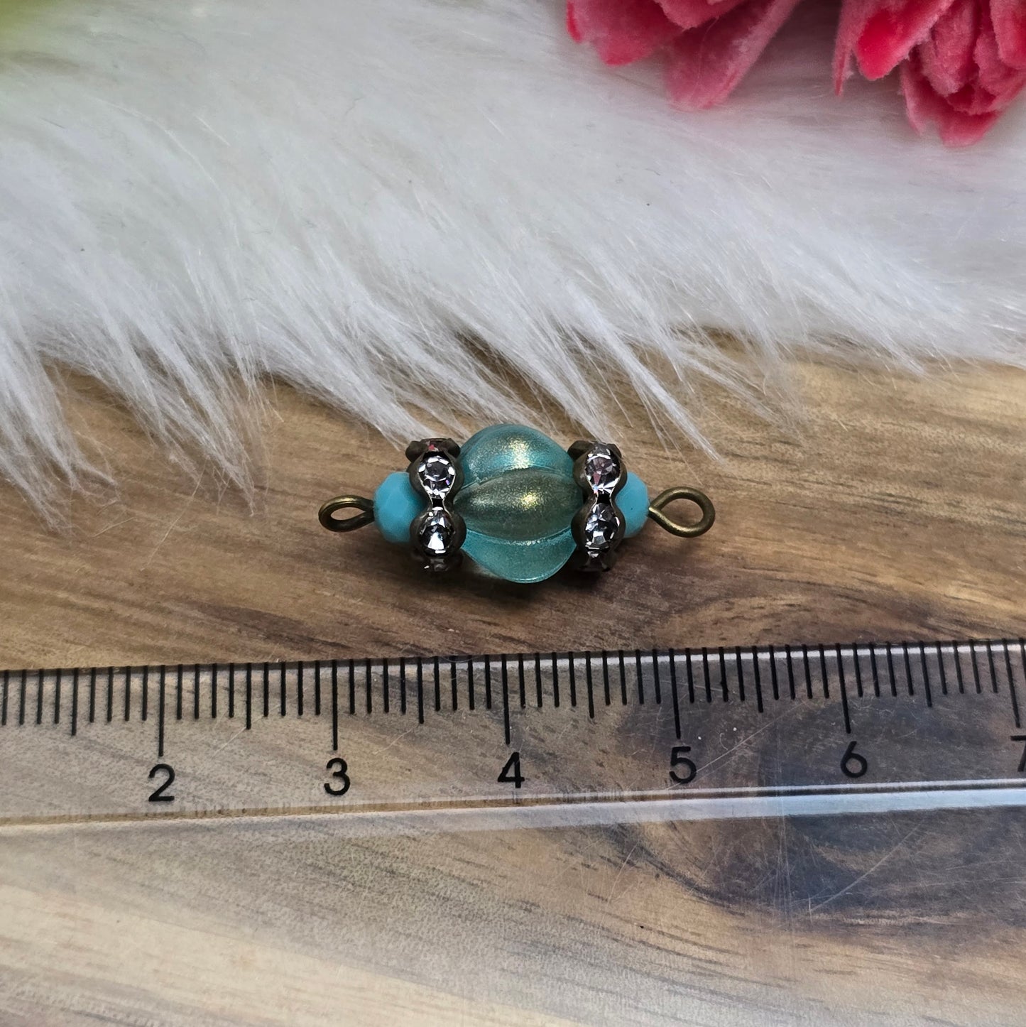 Das Bild zeigt zwei handgefertigte Verbinder mit mintfarbenen Glasperlen in Kürbisform und facettierten Kristallglasperlen. Strassrondelle sorgen für funkelnde Akzente, während antik bronzefarbene Metallelemente dem Design einen eleganten Vintage-Charme verleihen. Die Verbinder sind ca. 25mm groß und ideal für Schmuckkreationen.