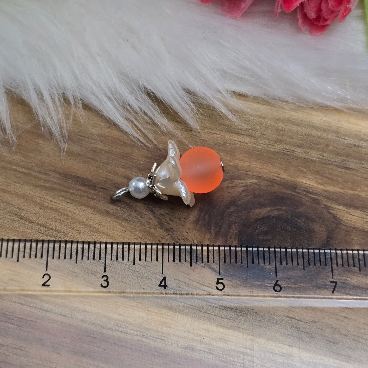 Das Bild zeigt ein 30-teiliges Bastelset zur Schmuckherstellung, ideal für kreative Bastler. In dem Set sind Materialien enthalten, um 6 Blumenanhänger in Orange und Weiß zu gestalten. Zu sehen sind verschiedene Komponenten: matte orangefarbene Glasperlen, cremeweiße Acrylperlen, weiße Blütenkäppchen und antik silberfarbige Sternkäppchen. Alle Teile sind sorgfältig angeordnet, um die Vielseitigkeit und Farbpalette des Sets hervorzuheben. Dieses Set bietet die perfekte Grundlage für die Gestaltung einzigarti