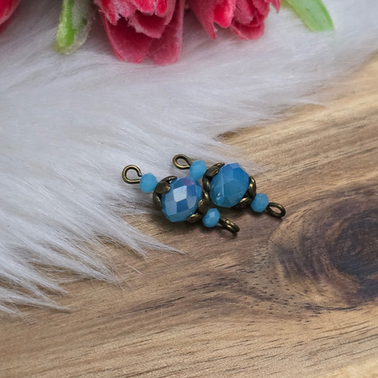 Das Bild zeigt zwei handgefertigte Schmuckverbinder zur individuellen Schmuckfertigung! Die funkelnden, facettierten Kristallglasperlen strahlen eine dezente Wärme aus und harmonieren perfekt mit den antik bronzefarbigen Metallelementen.