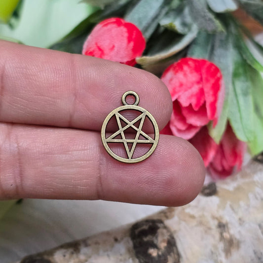 Das Bild zeigt kleine Anhänger in Form eines invertierten Pentagramms, die in antik bronzefarbener Ausführung gestaltet sind. Jeder Anhänger hat eine Größe von etwa 16 x 13 mm und ist in einem Ring gefasst. Die Oberfläche der Anhänger ist leicht strukturiert und hat eine matte, metallische Optik, die dem Produkt einen rustikalen Charme verleiht. Die Anhänger sind gleichmäßig angeordnet und bieten einen klaren Blick auf die charakteristische Form des invertierten Pentagramms.