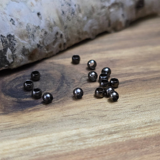 Das Bild zeigt Quetschperlen in Anthrazit (geschwärzt) in Kugelform. Sie eignen sich hervorragend zum Fixieren von Perlen oder zum Bilden von Schlaufen um Verschlüsse anzubringen.