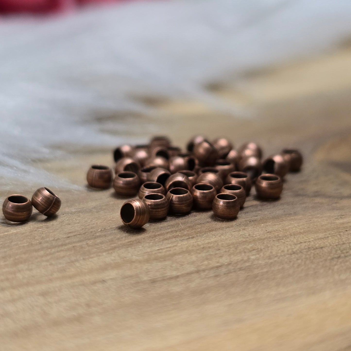 Das Bild zeigt Quetschperlen in Kugelform, antik kupferfarbig mit einem Durchmesser von 2,5mm. Ideal zum Fixieren von Perlen.