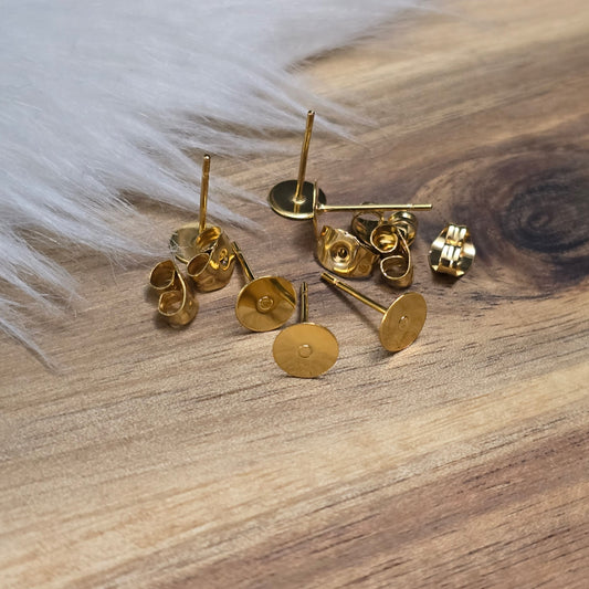 Das Bild zeigt Ohrstecker mit runder Klebeplatte aus Edelstahl in gold mit Flügelmuttern.