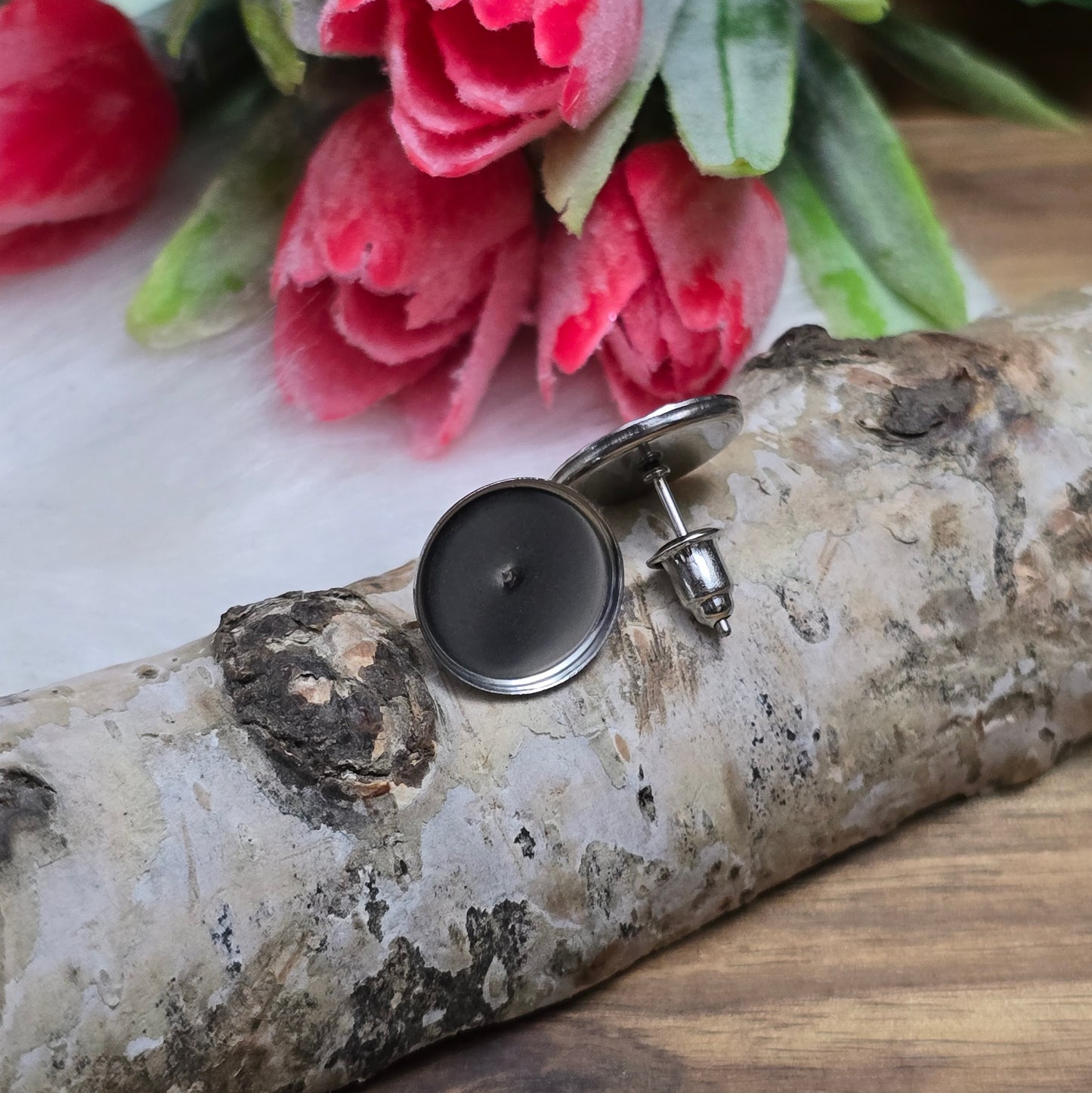 Das Bild zeigt Ohrstecker aus Edelstahl mit runder Klebewanne in der Farbe silber.