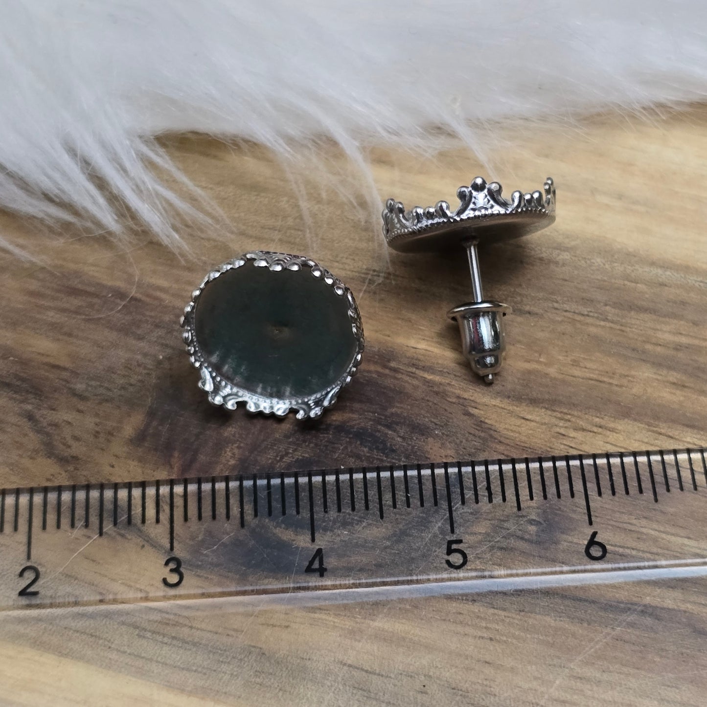 Das Bild zeigt Ohrstecker mit Klebewanne aus 304 Edelstahl, für 12mm Cabochons in der Farbe silber, mit Designrand.
