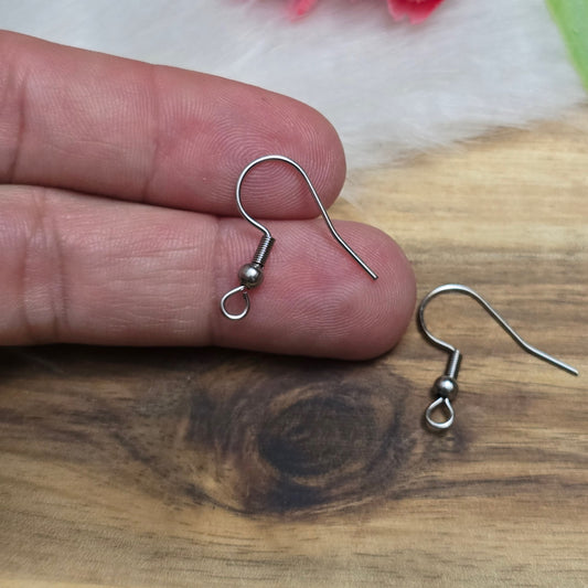 Das Bild zeigt ein Paar French Ohrhaken aus 304 Edelstahl in silberfarbener Optik. Die Haken haben eine geschwungene Form mit einer kleinen Kugel nahe der Öse, die zur Befestigung von Anhängern oder Perlen dient. Die Oberfläche ist glatt und glänzend, was ihnen ein edles und modernes Aussehen verleiht. Die stabilen Haken sind leicht gebogen, sodass sie bequem ins Ohr eingeführt werden können.