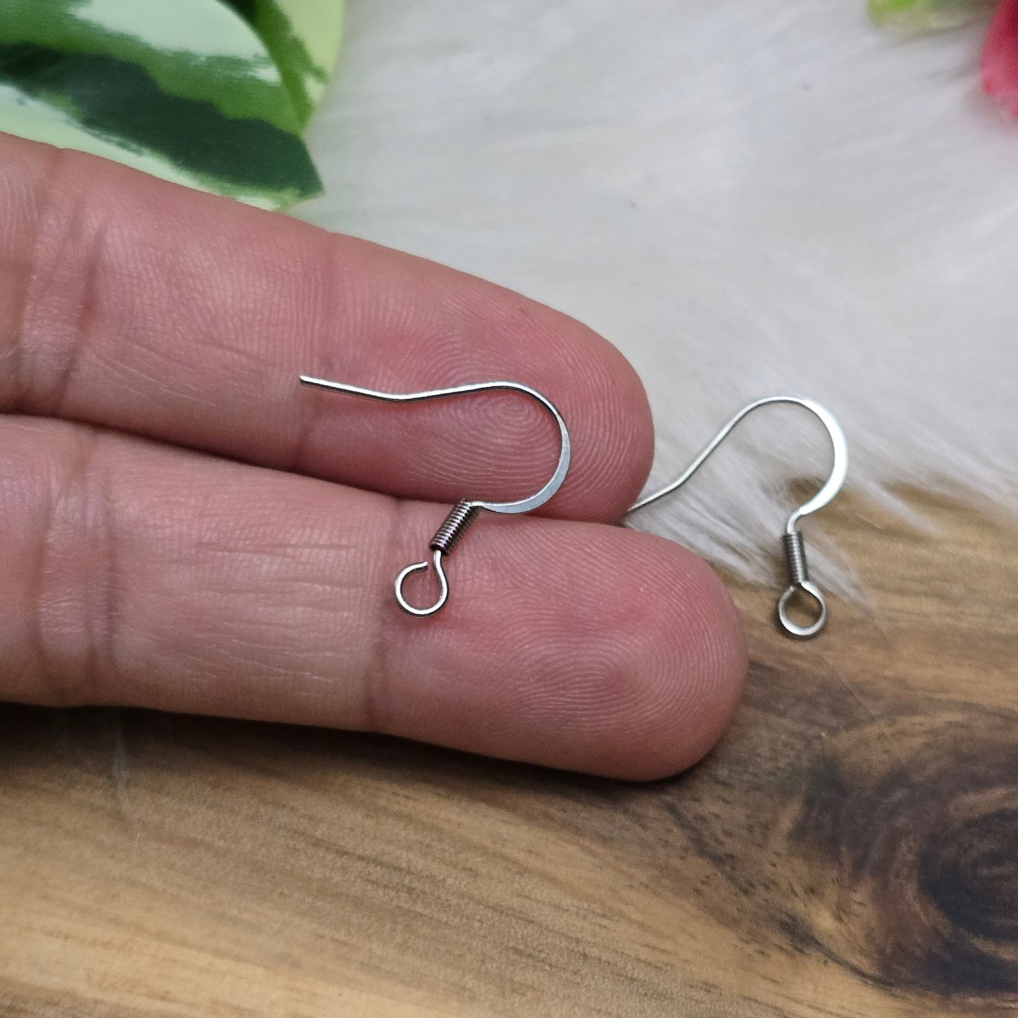 Das Bild zeigt ein Paar French Ohrhaken aus 304 Edelstahl in Silberfarbe. Die Haken haben eine elegante, geschwungene Form mit einer kleinen Öse am unteren Ende, die zur Befestigung von Anhängern oder Perlen dient. Die Oberfläche ist glatt und glänzend, was ihnen ein hochwertiges und modernes Aussehen verleiht. Mit einer Größe von etwa 16 mm sind sie ideal für die Gestaltung individueller Ohrringe.