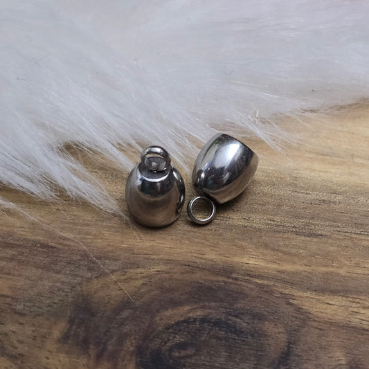 Das Bild zeigt zwei Endkappen aus hochwertigem 304 Edelstahl mit einem Durchmesser von 5 mm. Jede Endkappe verfügt über eine feste Öse, die für einen sicheren Halt sorgt und das Anbringen von Verschlüssen oder Anhängern erleichtert. Die silberfarbene Oberfläche der Endkappen verleiht ihnen ein elegantes und modernes Aussehen. Diese Endkappen sind ideal für die Fertigung von Quasten oder als Abschluss für dicke Bänder aus Materialien wie PU oder Leder, um ein professionelles Finish zu erzielen. Die kompakte