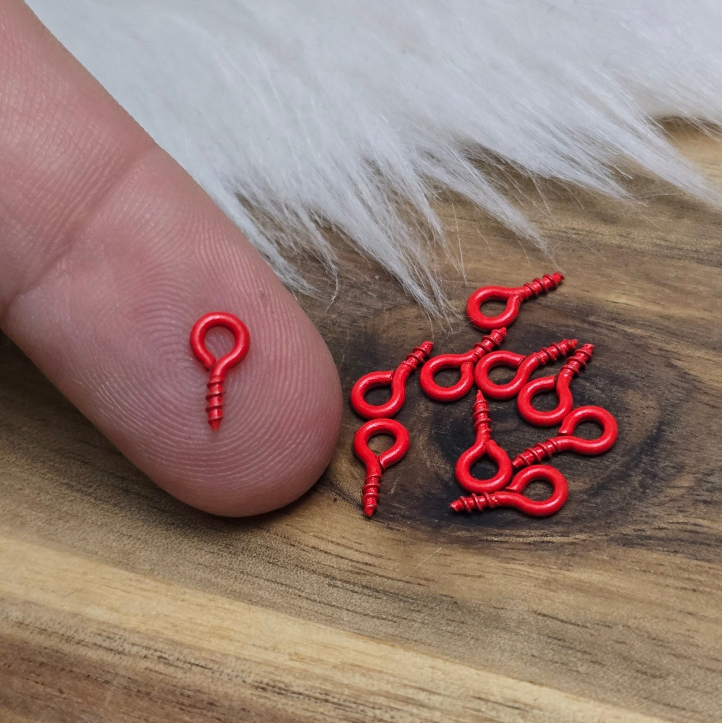 Das Bild zeigt ein Set von 10 farbig lackierten Schraubösen in verschiedenen lebhaften Farben, darunter Hellblau, Grün, Rot, Aqua, Weiß und Rosa. Jede Schrauböse hat die Abmessungen von ca. 8x4mm und ist sorgfältig gestaltet, um eine einfache Anwendung zu ermöglichen. Die Schraubösen sind ideal für das Einschrauben in Materialien wie Holz, Resin oder Acryl, um individuelle Anhänger zu kreieren. Die glänzende Oberfläche der Schraubösen sorgt für einen attraktiven Look, der jedem kreativen Projekt einen farbe