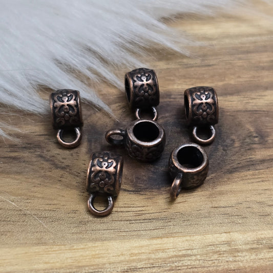 Das Bild zeigt antik kupferfarbige Metallperlen mit Öse.