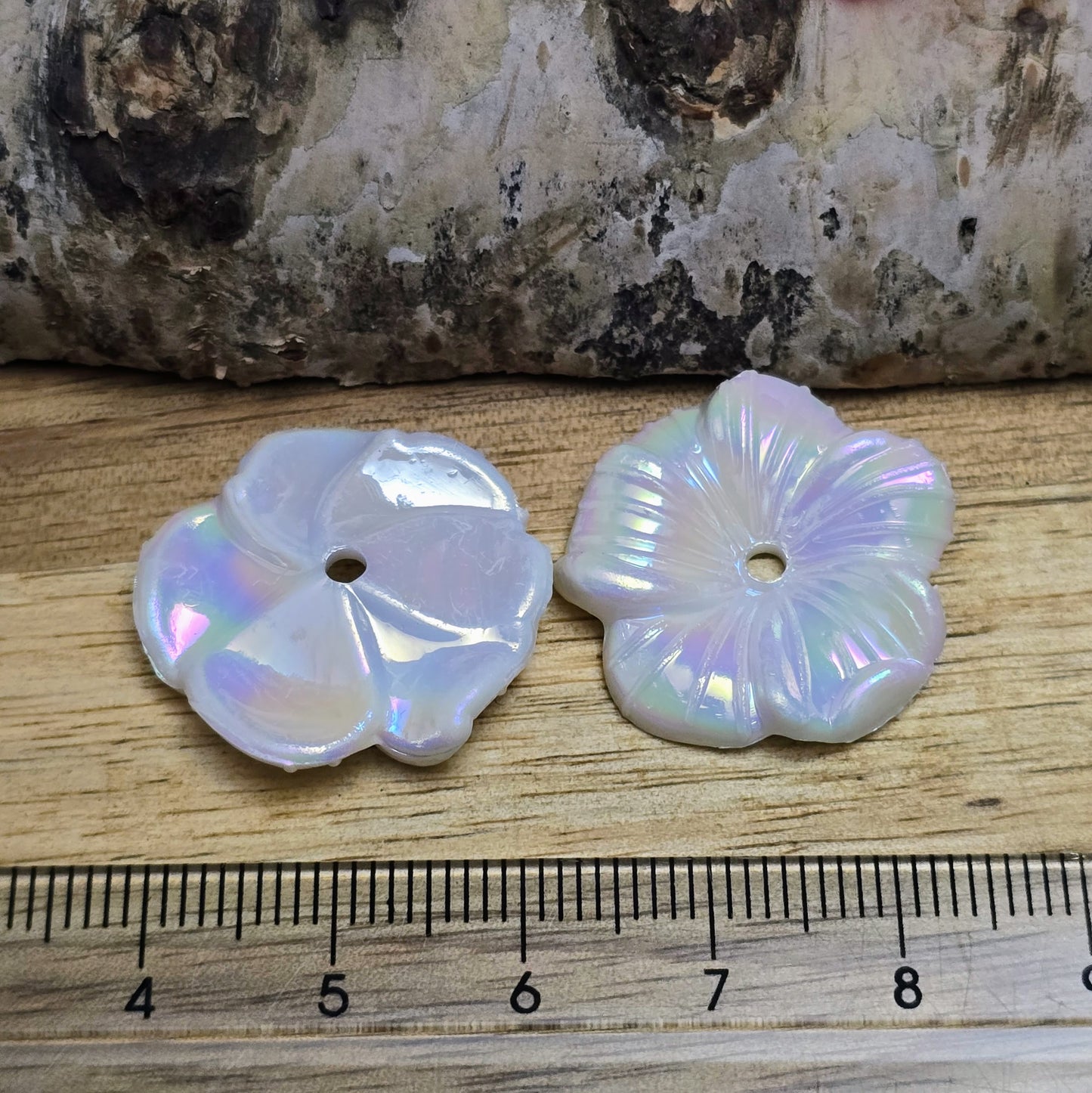 Diese 12 weißen, irisierenden Blumenperlen aus Acryl mit einem Durchmesser von 22 mm sind perfekt für deine kreativen Projekte! Ideal für Schmuck, Makramee und Dekorationen. Ihre schimmernde Oberfläche bringt blumigen Flair und ist eine wunderbare Ergänzung für Hochzeiten, Sommerfeste und andere festliche Anlässe.