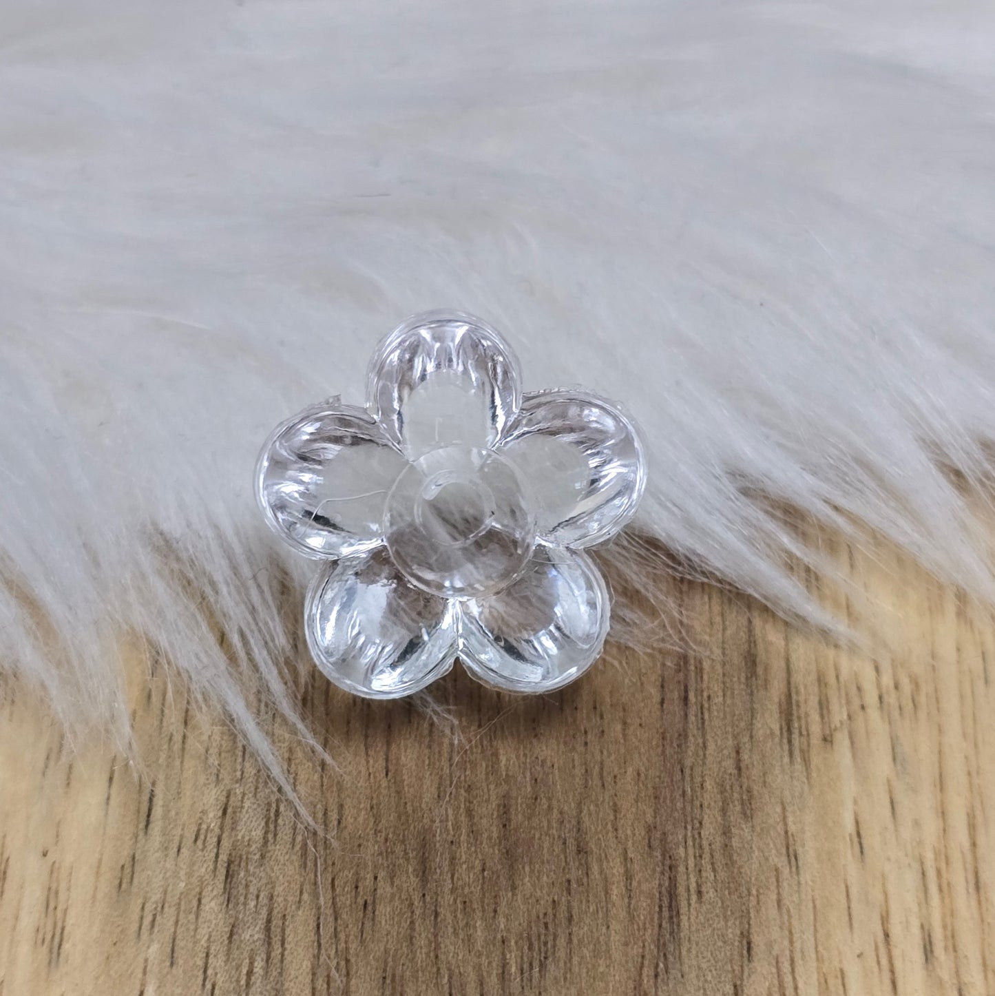 Klar transparente Acryl-Blumenperlen (18 mm) mit glänzender Oberfläche. Die filigrane Blütenform verleiht Schmuckstücken und Dekorationen eine elegante Note. Mit einem 3,5 mm großen Fädelloch lassen sie sich leicht auf Bänder oder Schnüre auffädeln. Ideal für DIY-Projekte, Hochzeiten oder Bastelarbeiten.