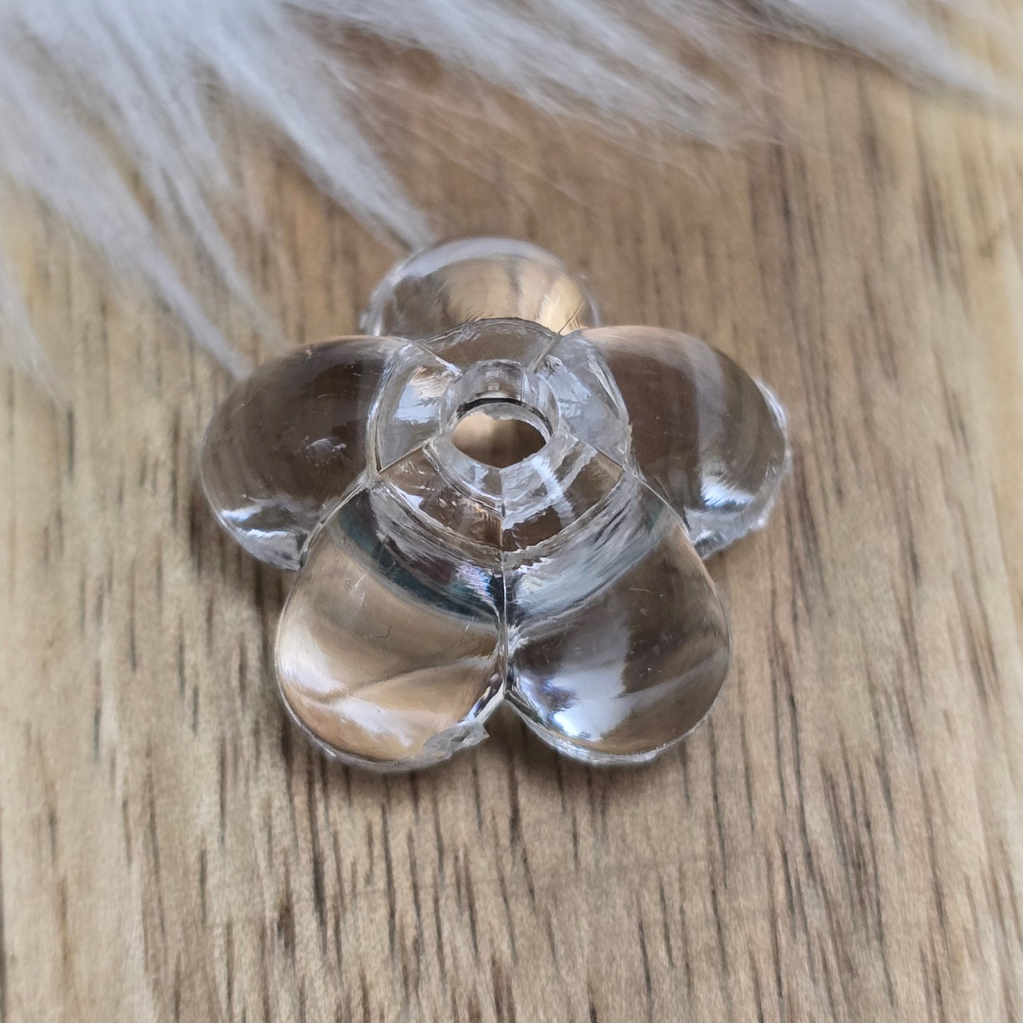 Klar transparente Acryl-Blumenperlen (18 mm) mit glänzender Oberfläche. Die filigrane Blütenform verleiht Schmuckstücken und Dekorationen eine elegante Note. Mit einem 3,5 mm großen Fädelloch lassen sie sich leicht auf Bänder oder Schnüre auffädeln. Ideal für DIY-Projekte, Hochzeiten oder Bastelarbeiten.