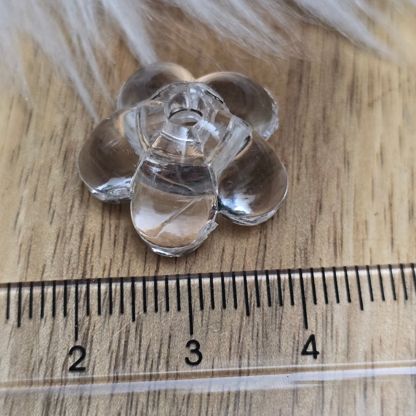 Klar transparente Acryl-Blumenperlen (18 mm) mit glänzender Oberfläche. Die filigrane Blütenform verleiht Schmuckstücken und Dekorationen eine elegante Note. Mit einem 3,5 mm großen Fädelloch lassen sie sich leicht auf Bänder oder Schnüre auffädeln. Ideal für DIY-Projekte, Hochzeiten oder Bastelarbeiten.