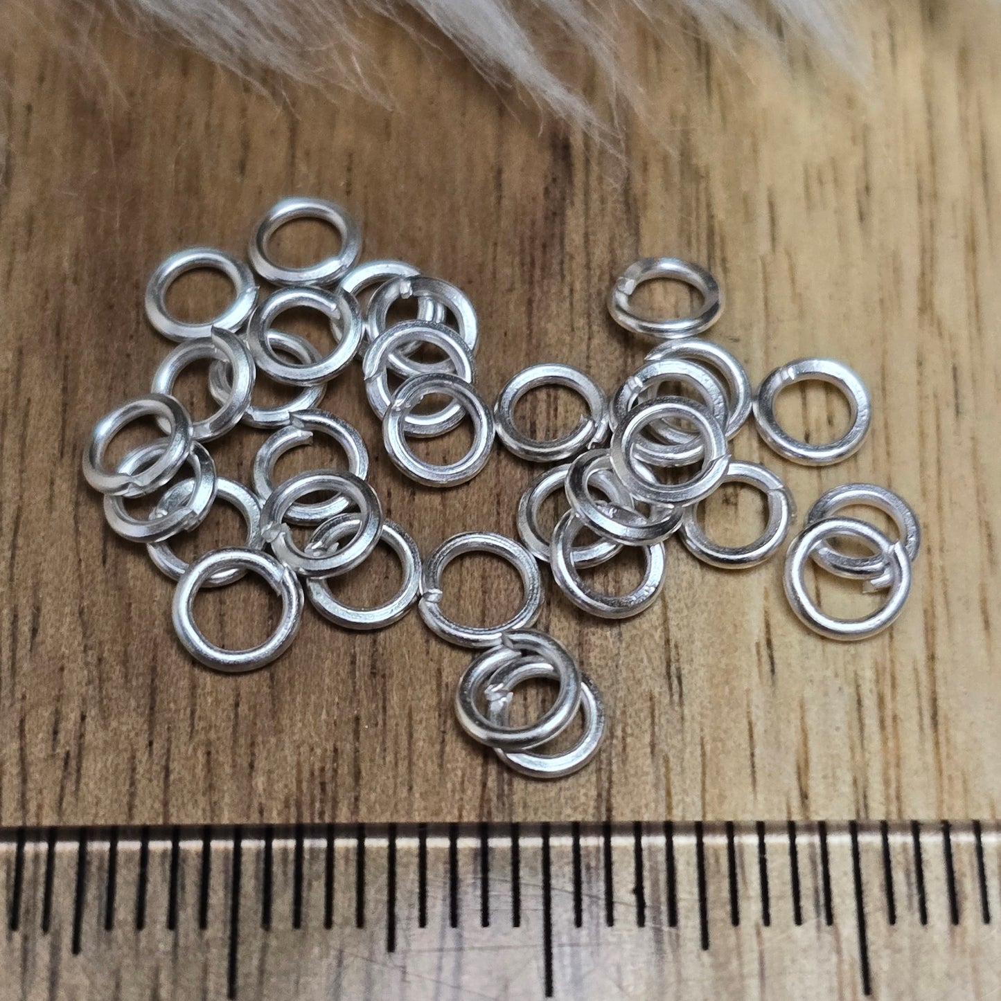 Das Bild zeigt 30 offene Biegeringe mit 4mm Durchmesser, perfekt für die Schmuckherstellung. Sie eignen sich hervorragend als Anhängerösen für Kettenanhänger oder als Verbindungsringe in verschiedenen Designs.
