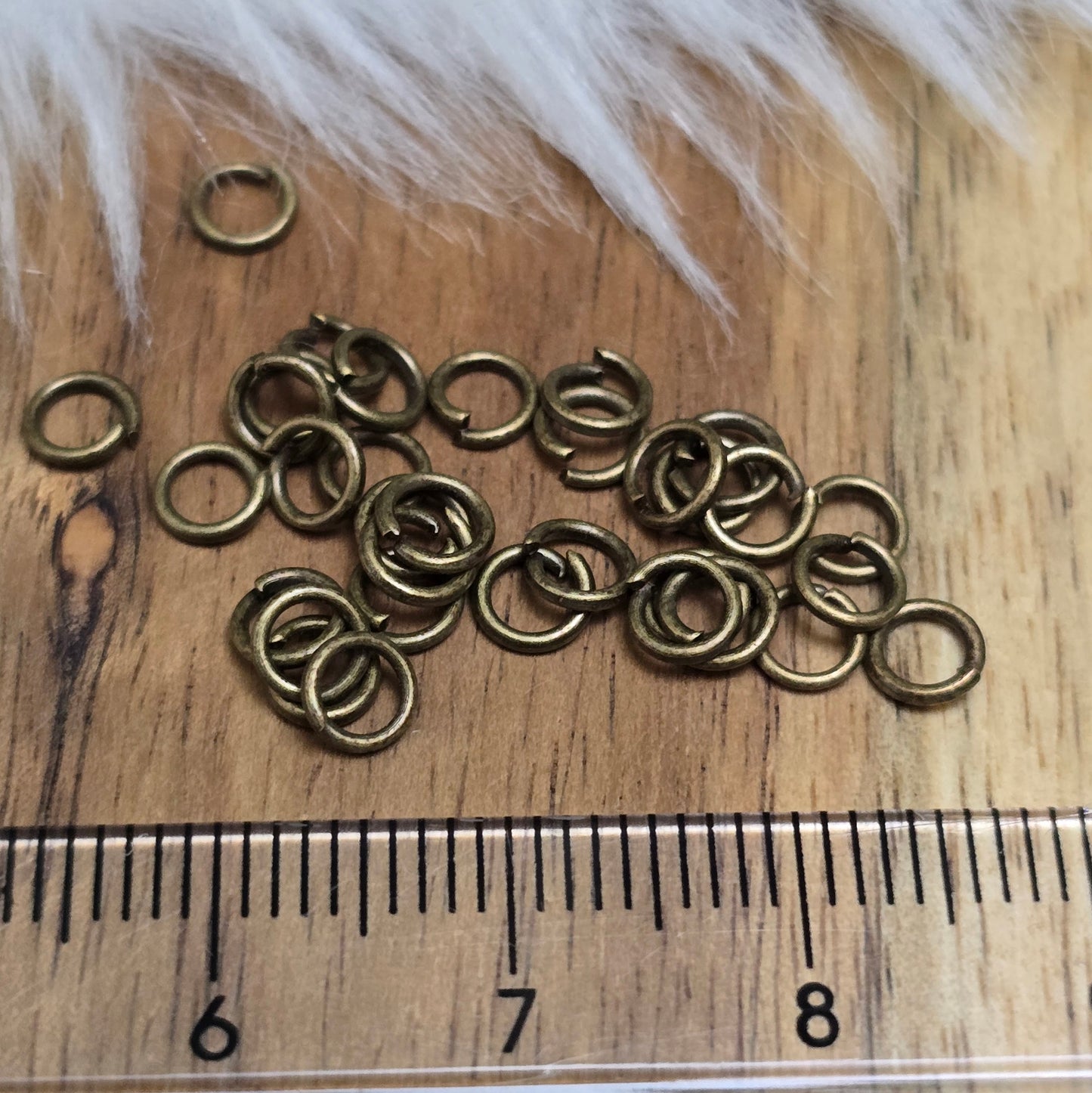 Das Bild zeigt 30 offene Biegeringe mit 4,4mm Durchmesser in antik bronzefarbig, perfekt für die Schmuckherstellung. Sie eignen sich hervorragend als Anhängerösen für Kettenanhänger oder als Verbindungsringe in verschiedenen Designs.