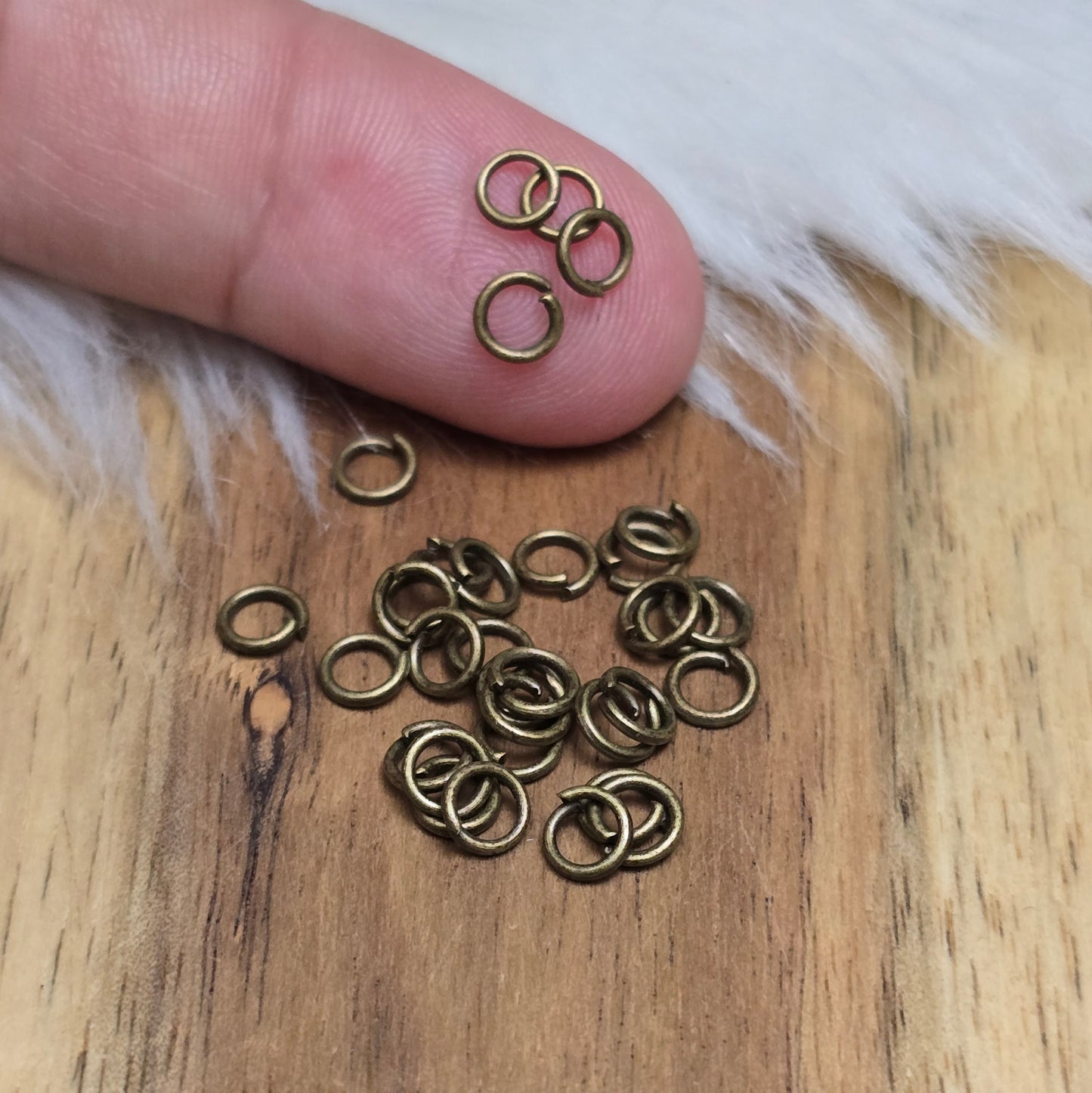Das Bild zeigt 30 offene Biegeringe mit 4,4mm Durchmesser in antik bronzefarbig, perfekt für die Schmuckherstellung. Sie eignen sich hervorragend als Anhängerösen für Kettenanhänger oder als Verbindungsringe in verschiedenen Designs.