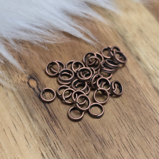 Das Bild zeigt 30 doppelte Binderinge in antikem Kupfer-Finish sind ein unverzichtbares Zubehör für die Schmuckherstellung. Durch ihre doppelte Wicklung bieten sie eine besonders stabile und sichere Verbindung, sodass Anhänger, Charms und Verschlüsse zuverlässig befestigt bleiben.