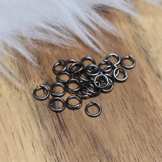 Das Bild zeigt 30 offene Biegeringe in gunmetal black mit 4,2mm Durchmesser, ein unverzichtbares Zubehör für die Schmuckherstellung. Ideal um Charms und Verschlüsse zuverlässig zu befestigen.