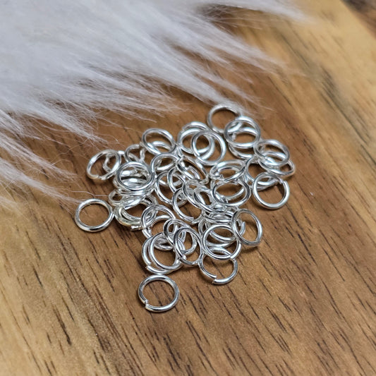 Das Bild zeigt 40 offene Biegeringe in versilbert mit einem Durchmesser von 4,2mm, ein unverzichtbares Zubehör für die Schmuckherstellung. Ideal um Charms und Verschlüsse zuverlässig zu befestigen.