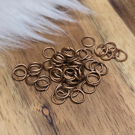 Das Bild zeigt 50 offene Biegeringe in antik kupferfarbig mit einem Durchmesser von 5mm, ein unverzichtbares Zubehör für die Schmuckherstellung. Ideal um Charms und Verschlüsse zuverlässig zu befestigen.