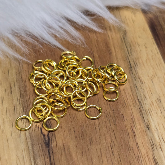 Das Bild zeigt 50 offene Biegeringe in vergoldet mit einem Durchmesser von 5mm, ein unverzichtbares Zubehör für die Schmuckherstellung. Ideal um Charms und Verschlüsse zuverlässig zu befestigen.