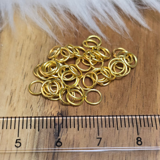 Das Bild zeigt 50 offenen Biegeringe in vergoldet mit einem Durchmesser von 5mm, ein unverzichtbares Zubehör für die Schmuckherstellung. Ideal um Charms und Verschlüsse zuverlässig zu befestigen.