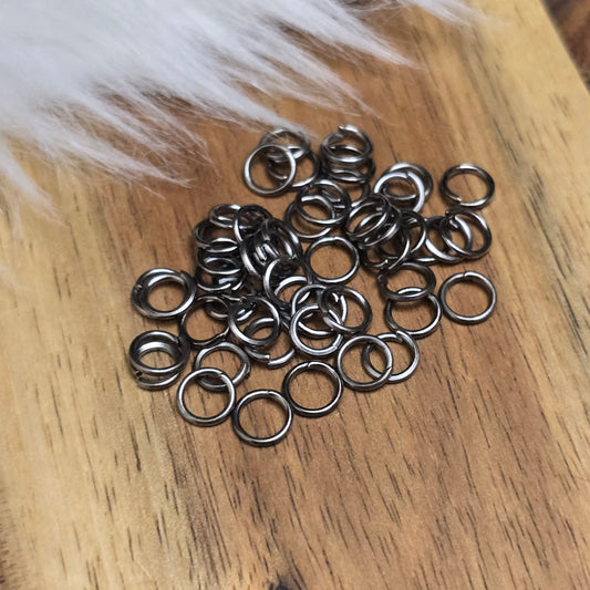 Das Bild zeigt 50 offene Biegeringe in gunmetal black mit einem Durchmesser von 5mm, ein unverzichtbares Zubehör für die Schmuckherstellung. Ideal um Charms und Verschlüsse zuverlässig zu befestigen.