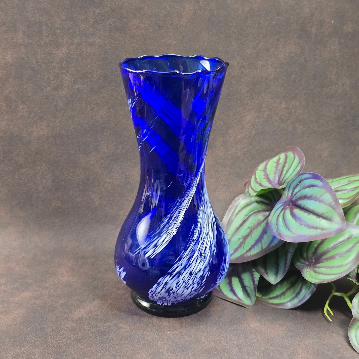 Mundgeblasene Vintage-Vase aus blauem Glas mit weißen Wirbeln, 19 cm hoch, 70er Jahre DDR. Authentisches Designobjekt mit kleinen Gebrauchsspuren.