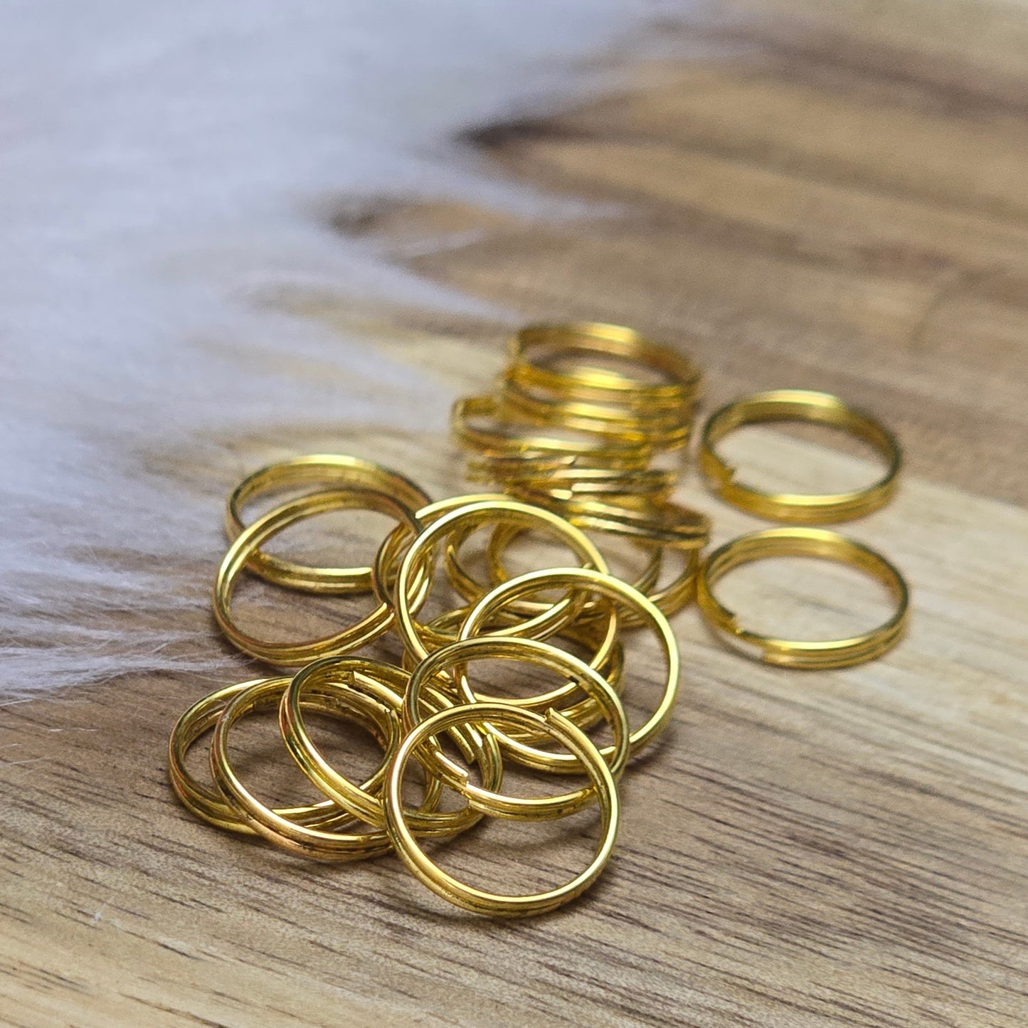 Das Bild zeigt 20 doppelte Binderinge in goldfarbig mit einem Durchmesser von 9,7mm. Die Verbindungsringe sind ein unverzichtbares Zubehör für die Schmuckherstellung. Durch ihre doppelte Wicklung bieten sie eine besonders stabile und sichere Verbindung, sodass Anhänger, Charms und Verschlüsse zuverlässig befestigt bleiben.
