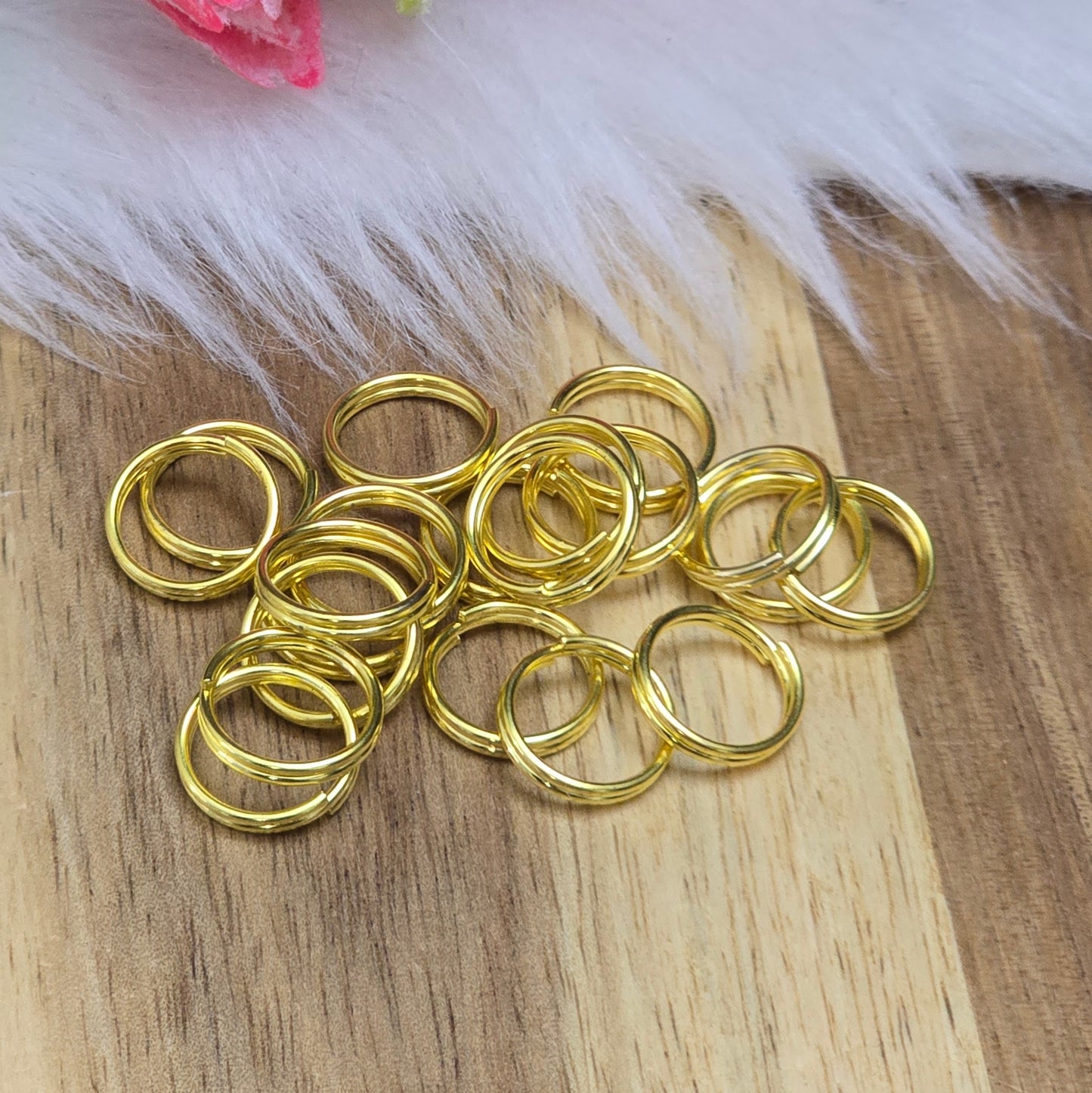 Das Bild zeigt 20 doppelte Binderinge in goldfarbig mit einem Durchmesser von 10mm. Die Verbindungsringe sind ein unverzichtbares Zubehör für die Schmuckherstellung. Durch ihre doppelte Wicklung bieten sie eine besonders stabile und sichere Verbindung, sodass Anhänger, Charms und Verschlüsse zuverlässig befestigt bleiben.