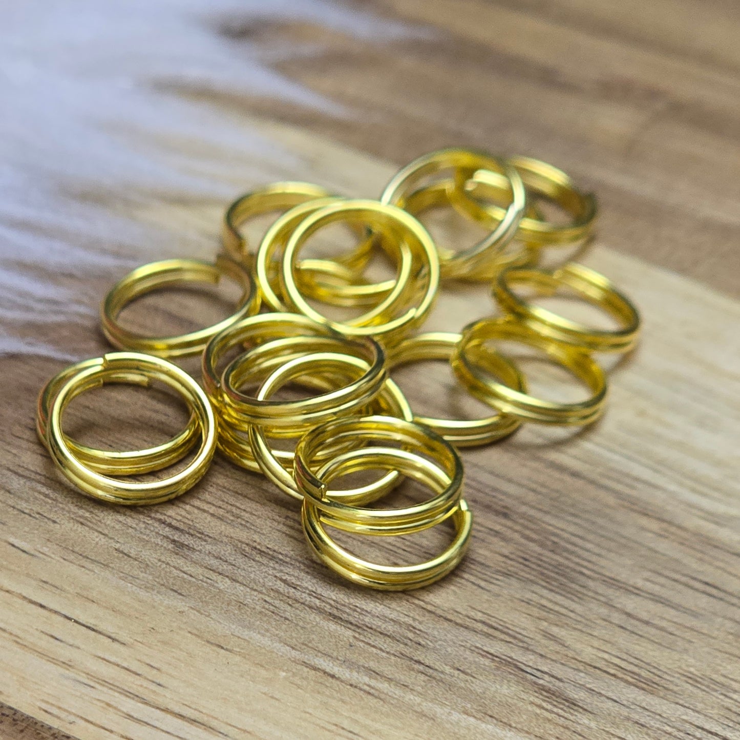 Das Bild zeigt 20 doppelte Binderinge in goldfarbig mit einem Durchmesser von 10mm. Die Verbindungsringe sind ein unverzichtbares Zubehör für die Schmuckherstellung. Durch ihre doppelte Wicklung bieten sie eine besonders stabile und sichere Verbindung, sodass Anhänger, Charms und Verschlüsse zuverlässig befestigt bleiben.