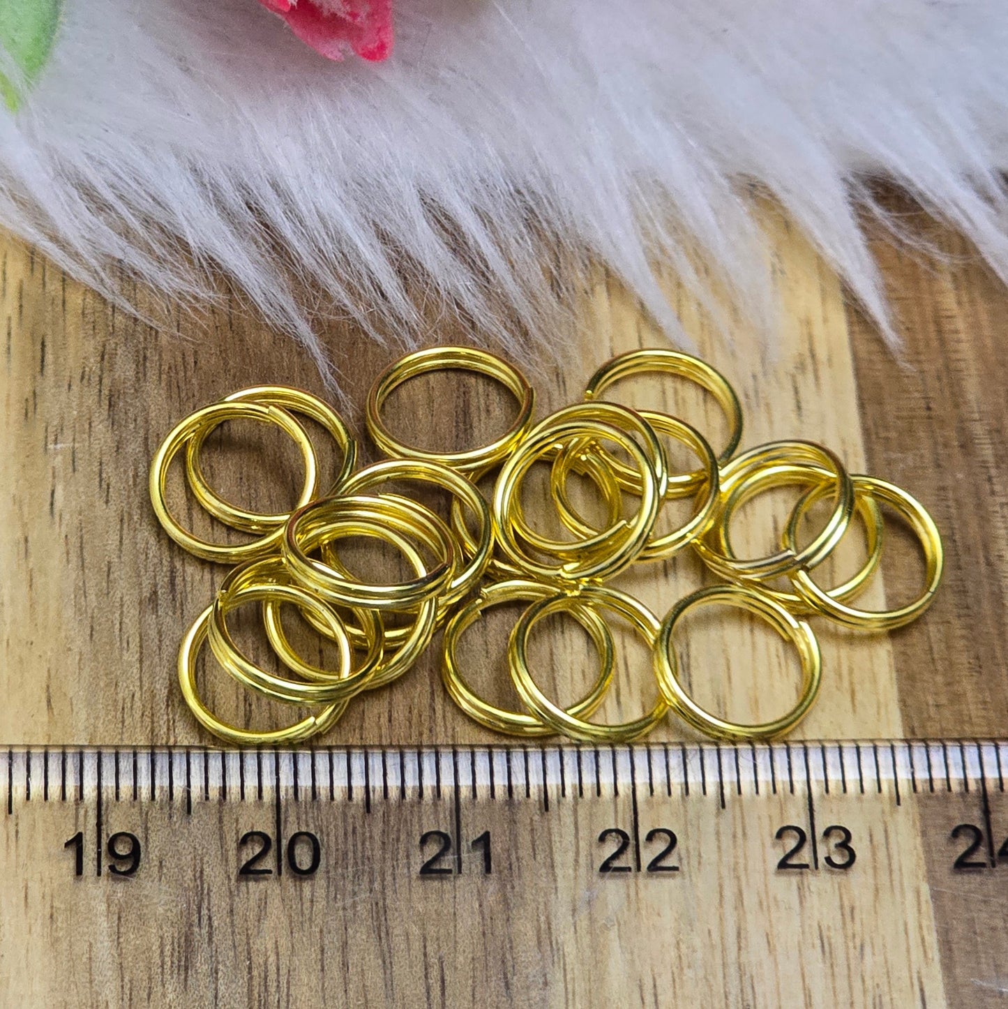 Das Bild zeigt 20 doppelte Binderinge in goldfarbig mit einem Durchmesser von 10mm. Die Verbindungsringe sind ein unverzichtbares Zubehör für die Schmuckherstellung. Durch ihre doppelte Wicklung bieten sie eine besonders stabile und sichere Verbindung, sodass Anhänger, Charms und Verschlüsse zuverlässig befestigt bleiben.