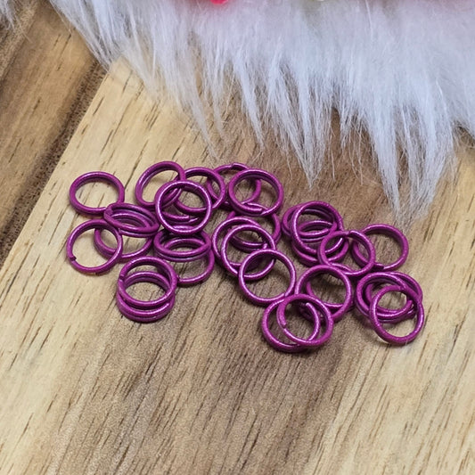 Das Bild zeigt 30 doppelte Binderinge in der Farbe Magenta mit einem Durchmesser von 6mm. Die Verbindungsringe sind ein unverzichtbares Zubehör für die Schmuckherstellung. Durch ihre doppelte Wicklung bieten sie eine besonders stabile und sichere Verbindung, sodass Anhänger, Charms und Verschlüsse zuverlässig befestigt bleiben.