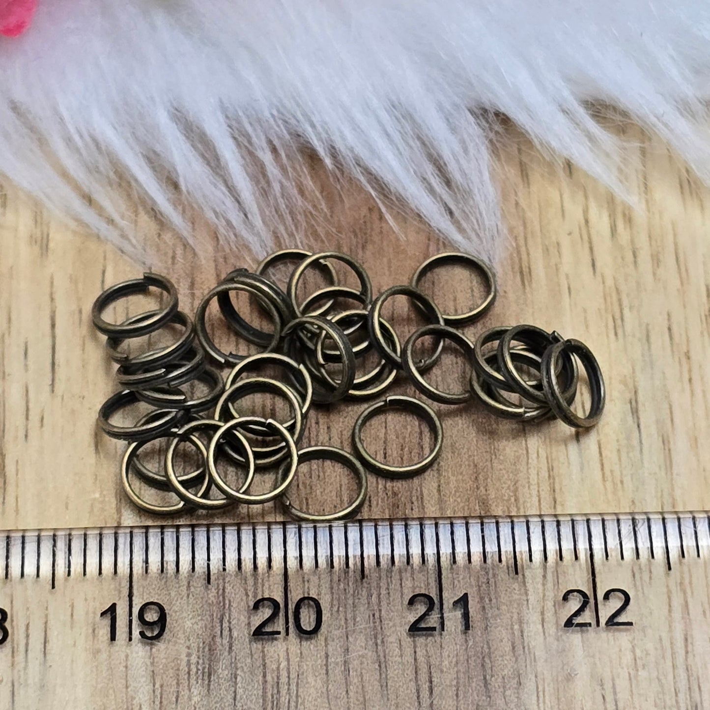 Das Bild zeigt 30 doppelte Binderinge in antikem Bronze-Finish mit 6mm Durchmesser. Die Verbindungsringe sind ein unverzichtbares Zubehör für die Schmuckherstellung. Durch ihre doppelte Wicklung bieten sie eine besonders stabile und sichere Verbindung, sodass Anhänger, Charms und Verschlüsse zuverlässig befestigt bleiben.