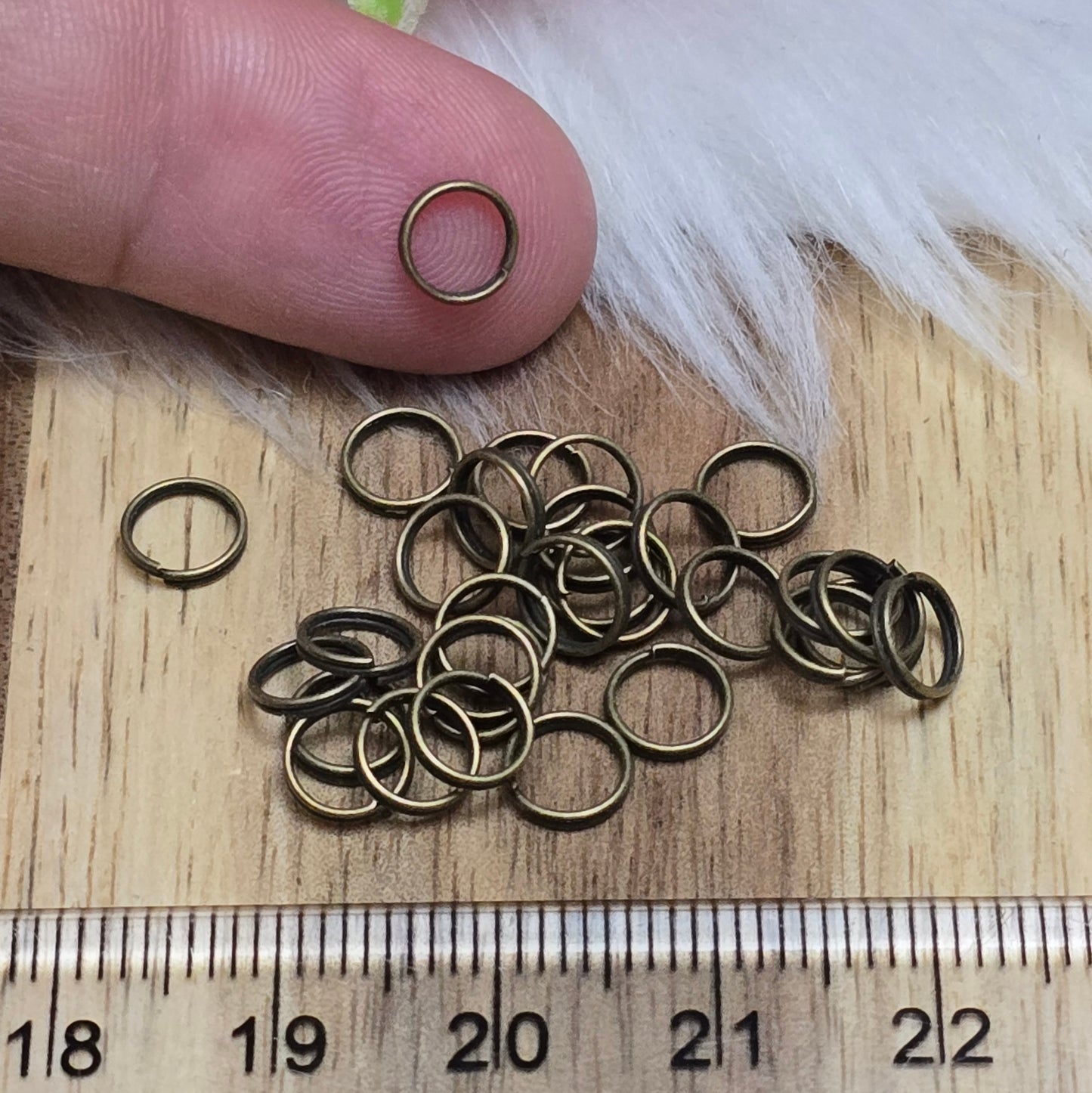 Das Bild zeigt 30 doppelte Binderinge in antikem Bronze-Finish mit 6mm Durchmesser. Die Verbindungsringe sind ein unverzichtbares Zubehör für die Schmuckherstellung. Durch ihre doppelte Wicklung bieten sie eine besonders stabile und sichere Verbindung, sodass Anhänger, Charms und Verschlüsse zuverlässig befestigt bleiben.