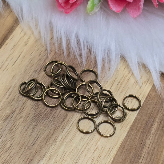 Das Bild zeigt 30 doppelte Binderinge in antik bronzefarbig mit einem Durchmesser von 7mm. Die Verbindungsringe sind ein unverzichtbares Zubehör für die Schmuckherstellung. Durch ihre doppelte Wicklung bieten sie eine besonders stabile und sichere Verbindung, sodass Anhänger, Charms und Verschlüsse zuverlässig befestigt bleiben.