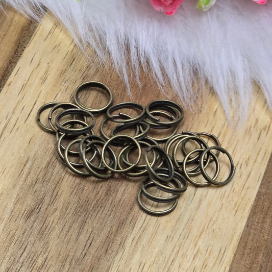 Das Bild zeigt 30 doppelte Binderinge in antik bronzefarbig mit einem Durchmesser von 8,3mm. Die Verbindungsringe sind ein unverzichtbares Zubehör für die Schmuckherstellung. Durch ihre doppelte Wicklung bieten sie eine besonders stabile und sichere Verbindung, sodass Anhänger, Charms und Verschlüsse zuverlässig befestigt bleiben.