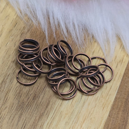 Das Bild zeigt 30 doppelte Binderinge in antik kupferfarbig mit einem Durchmesser von 8mm. Die Verbindungsringe sind ein unverzichtbares Zubehör für die Schmuckherstellung. Durch ihre doppelte Wicklung bieten sie eine besonders stabile und sichere Verbindung, sodass Anhänger, Charms und Verschlüsse zuverlässig befestigt