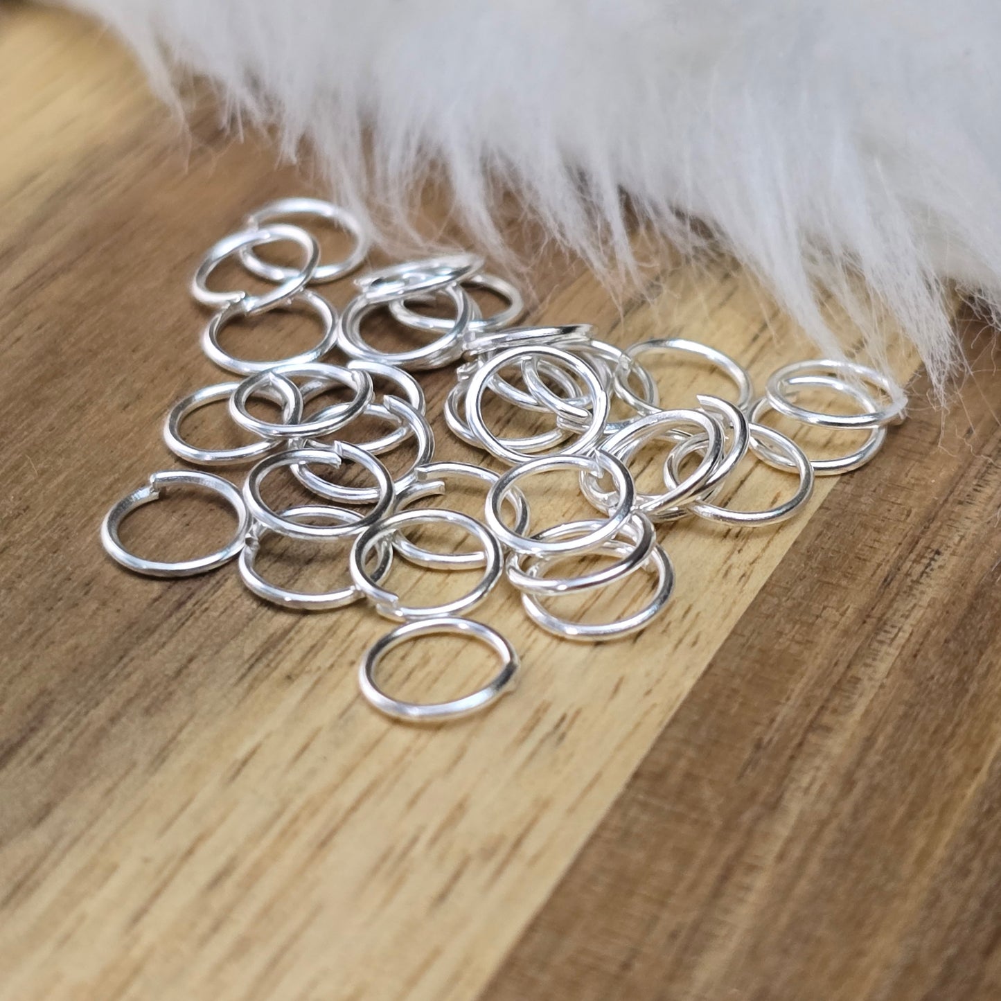 Das Bild zeigt 30 offene Biegeringe in versilbert mit einem Durchmesser von 7mm. Die Verbindungsringe sind ein unverzichtbares Zubehör für die Schmuckherstellung. Ideal um Charms und Verschlüsse zuverlässig zu befestigen.