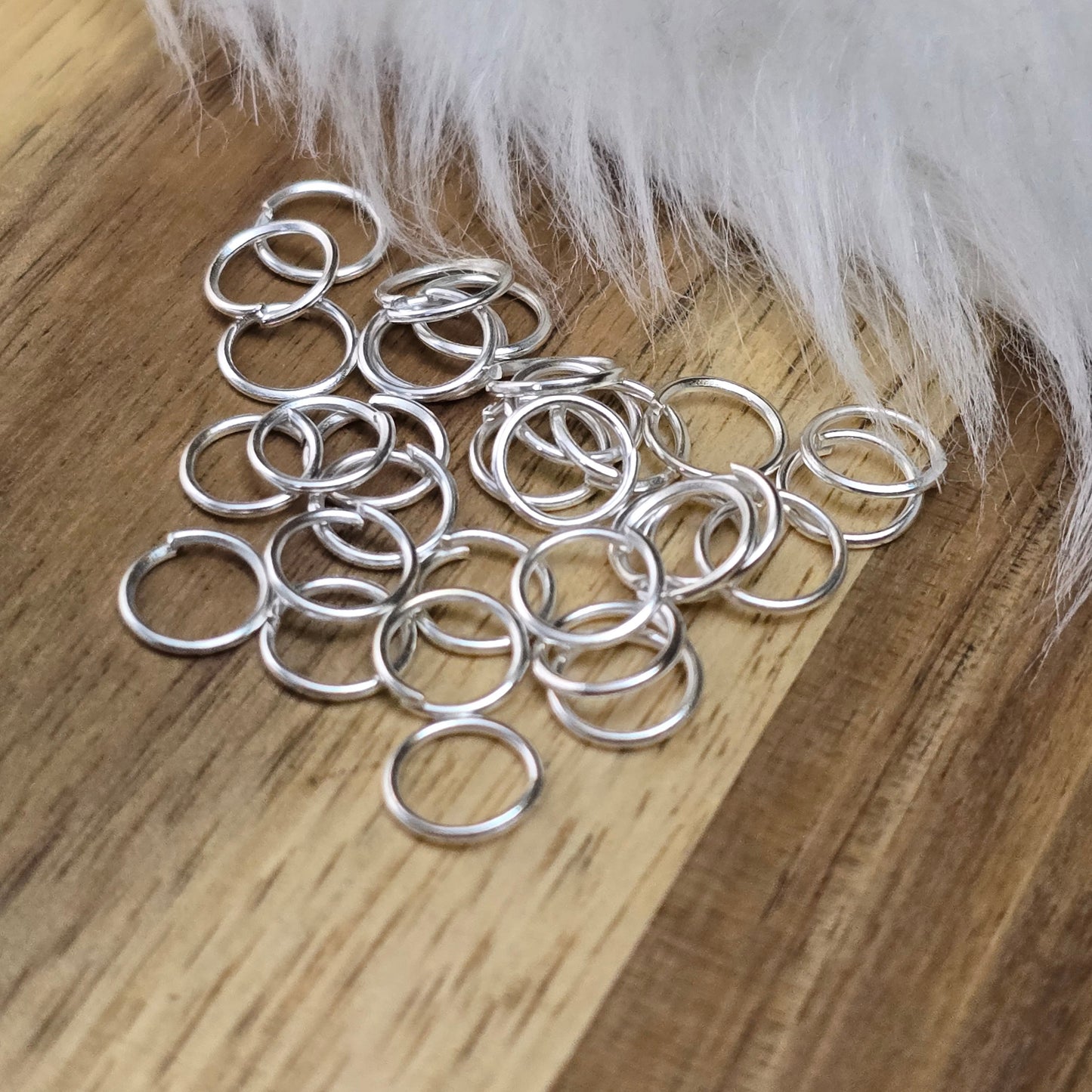 Das Bild zeigt 30 offene Biegeringe in versilbert mit einem Durchmesser von 7mm. Die Verbindungsringe sind ein unverzichtbares Zubehör für die Schmuckherstellung. Ideal um Charms und Verschlüsse zuverlässig zu befestigen.