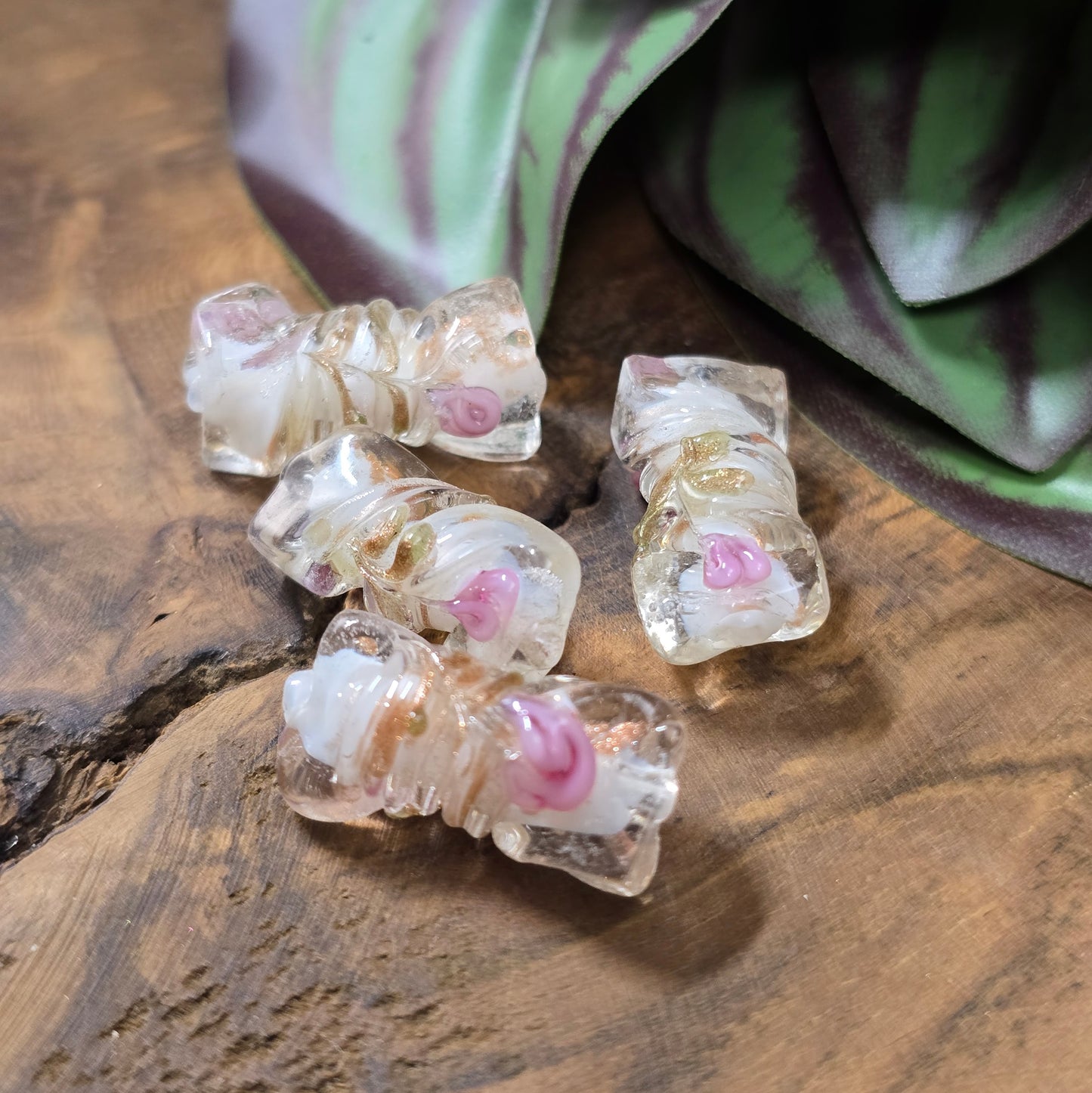 4 handgefertigte Glasperlen in gedrehter Walzenform (21mm), klar mit weißem Kern, Röschen & Glitzer – perfekt für romantischen DIY-Schmuck.