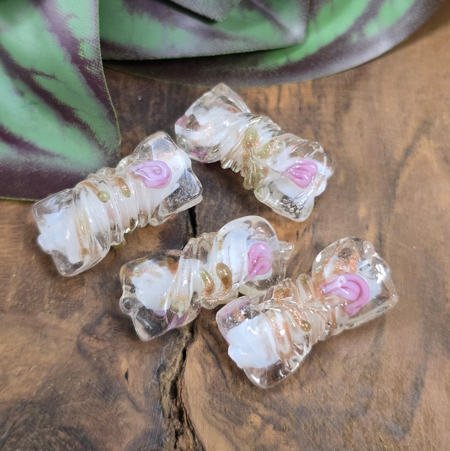 4 handgefertigte Glasperlen in gedrehter Walzenform (21mm), klar mit weißem Kern, Röschen & Glitzer – perfekt für romantischen DIY-Schmuck.
