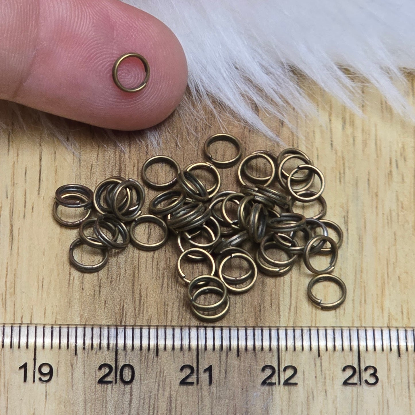 Das Bild zeigt 50 doppelte Binderinge in antikem Bronze-Finish. Die Verbindungsringe sind ein unverzichtbares Zubehör für die Schmuckherstellung. Durch ihre doppelte Wicklung bieten sie eine besonders stabile und sichere Verbindung, sodass Anhänger, Charms und Verschlüsse zuverlässig befestigt bleiben.