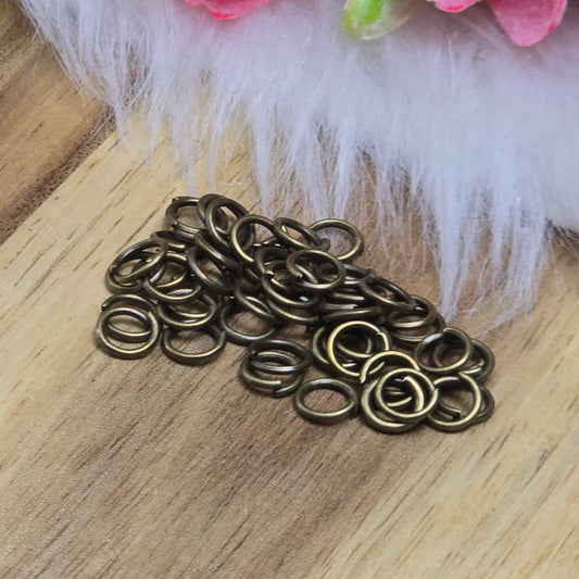 Das Bild zeigt 50 offene Biegeringe in antik bronzefarbig mit einem Durchmesser von 5mm. Die Verbindungsringe sind ein unverzichtbares Zubehör für die Schmuckherstellung. Ideal um Charms und Verschlüsse zuverlässig zu befestigen.